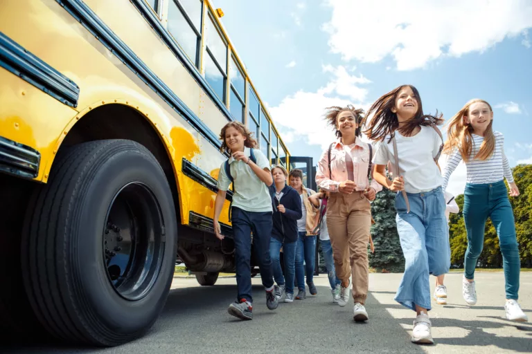 Students safely exiting a yellow school bus - Busology Tech school bus solutions.